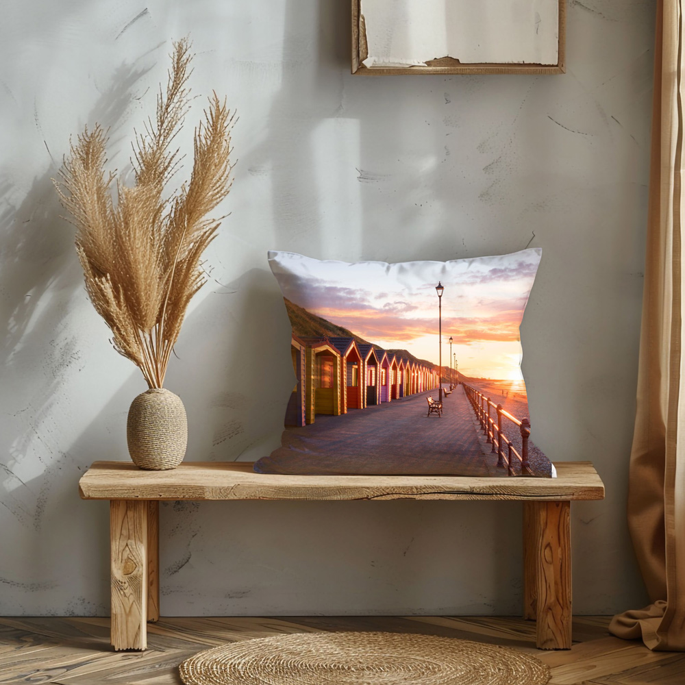 Saltburn Beach Huts At Sunset Cushion Displayed on a chair